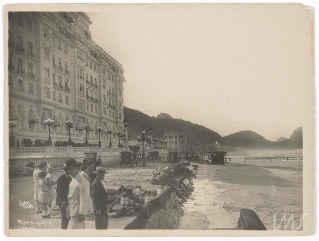 Há quase 100 anos, Copacabana teve ressaca que ficou conhecida como 'os caprichos do mar' 1 Pessoas observando os estragos da ressaca da noite anterior nas proximidades do Copacabana Palace em fotografia de Augusto Malta em Há quase 100 anos, Copacabana teve ressaca que ficou conhecida como 'os caprichos do mar'